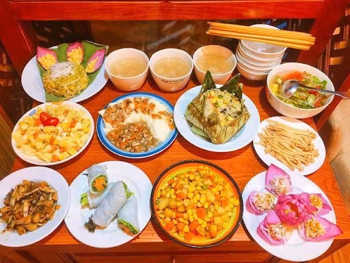 Mâm cơm chay 11 món: 1. Xôi cốm hạt sen dừa, 2. Đậu sốt nấm, 3. Phở cuốn rau, 4. Salad hoa quả, 5. Món xào thập cẩm, 6. Nấm rơm kho sả ớt, 7. Cơm sen, 8. Nấm xào xì dầu, 9. Chè hạt sen long nhãn, 10. Bánh bí đỏ nhân đậu xanh, 11. Canh nấm chay) (Ảnh eva.vn)