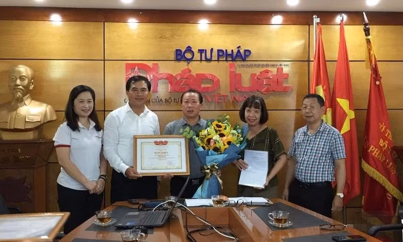 Thứ trưởng Bộ Xây dựng Lê Quang Hùng trao Bằng khen của Bộ trưởng Bộ Xây dựng cho tập thể Báo Pháp luật Việt Nam. Ảnh: Kim Quy