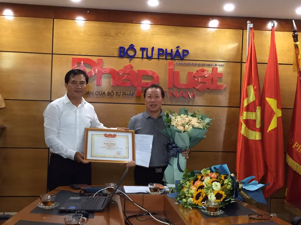 Trao bằng khen của Bộ trưởng Bộ Xây dựng cho Tổng biên tập Báo Pháp luật Việt Nam. Ảnh: Kim Quy
