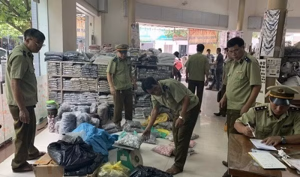 Lực lượng chức năng kiểm tra hàng nhái tại cơ sở kinh doanh. Ảnh: TL.