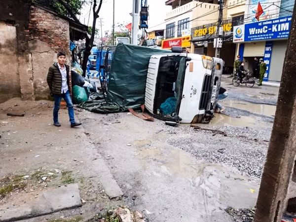 Xe tải chở hàng bị mất thăng bằng, lật nghiêng vì một bánh xe xuống hố quá sâu tại đoạn 600m đầy “ổ voi” trên đường 181.
