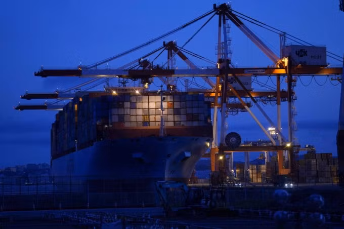 Tàu container Maersk Eindhoven do Maersk Line Ltd. điều hành, được thả neo bên cạnh giàn cẩu tại một bến tàu ở Yokohama, Nhật Bản, vào ngày 19 tháng 7 - Ảnh: BLOOMBERG
