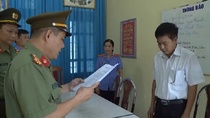 Ông Trần Xuân Yến (áo trắng), Phó giám đốc Sở GDĐT tỉnh Sơn La nghe tống đạt quyết định khởi tố bị can. (Ảnh TL)