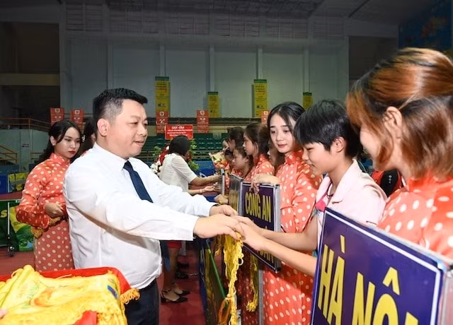 Phó Tổng Biên tập Báo Nhân Dân Quế Đình Nguyên trao cờ lưu niệm cho các đoàn. Ảnh: Báo nhandan