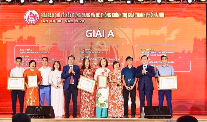 Ủy viên Bộ Chính trị, Bí thư Thành ủy Hà Nội Vương Đình Huệ và Ủy viên Trung ương Đảng, Tổng Biên tập Báo Nhân Dân, Phó Trưởng Ban Tuyên giáo Trung ương, Chủ tịch Hội Nhà báo Việt Nam Thuận Hữu trao giải cho các tác giả có tác phẩm đoạt Giải A Giải báo chí về Xây dựng Đảng và hệ thống chính trị. (Ảnh: Duy Linh)
