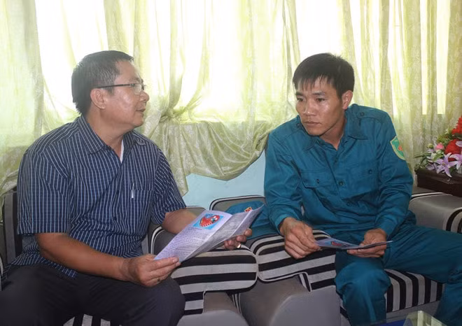 Ông Chu Minh Thanh, Chủ tịch UBND xã Ea M'Doal (trái), trao đổi nội dung hỗ trợ đóng BHXH tự nguyện với một thôn đội trưởng Ảnh: Trung Nguyên
