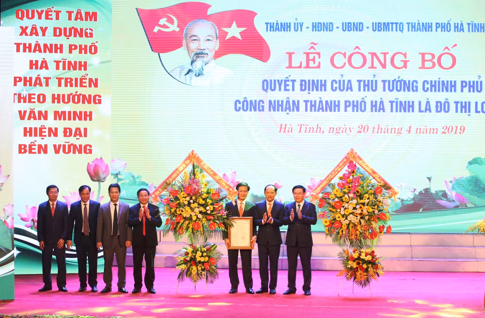 Phó Thủ tướng Chính phủ Vương Đình Huệ cùng lãnh đạo tỉnh Hà Tĩnh trao Quyết định công nhân, tặng hoa chúc mừng TP Hà Tĩnh là đô thị loại 2 trực thuộc tỉnh. Ảnh PV