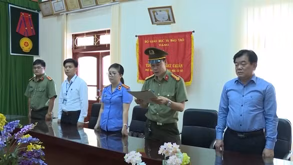 Ông Hoàng Tiến Đức (bìa phải) - giám đốc Sở GD-ĐT Sơn La, chứng kiến việc tống đạt quyết định khởi tố và lệnh bắt tạm giam ông Lò Văn Huynh - trưởng phòng khảo thí và quản lý chất lượng sở GD-ĐT tỉnh. Ảnh: tuoitre.vn