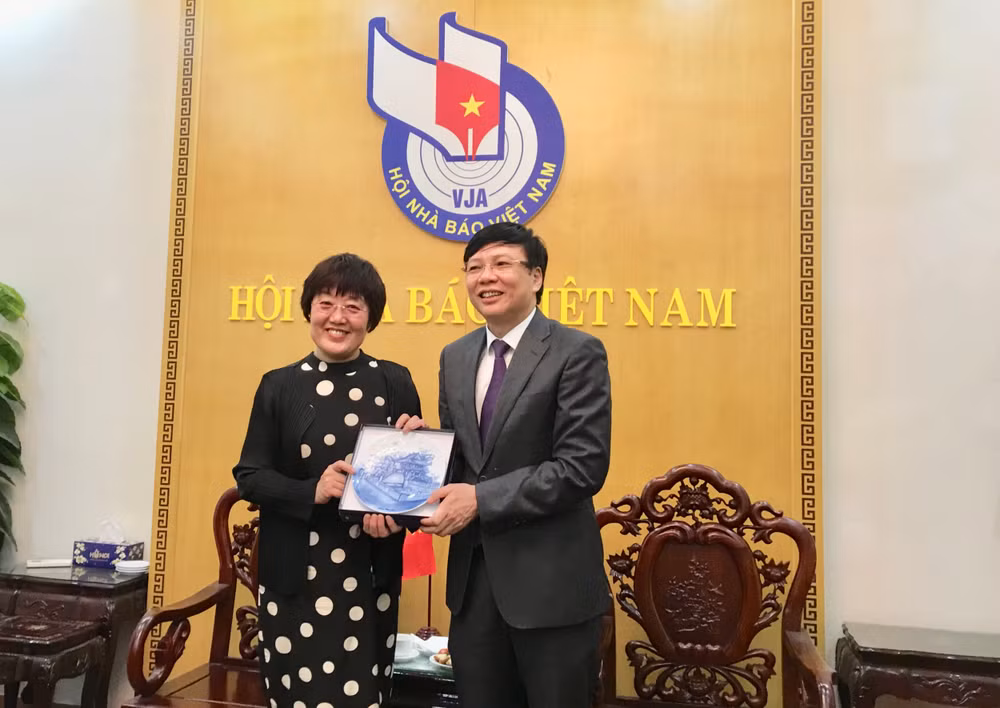 Ông Hồ Quang Lợi, Phó Chủ tịch Thường trực Hội Nhà báo Việt Nam tặng quà lưu niệm cho bà Vương Đông Mai, Thư ký Thường trực, Bí thư phụ trách đối ngoại, Ban Bí thư Hội Nhà báo toàn Trung Quốc. Ảnh: Hoàng Huy