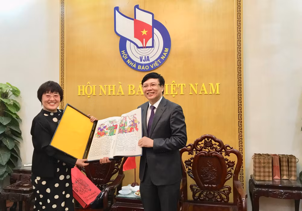 Bà Vương Đông Mai, Thư ký Thường trực, Bí thư phụ trách đối ngoại, Ban Bí thư Hội Nhà báo toàn Trung Quốc tặng quà lưu niệm cho ông Hồ Quang Lợi, Phó Chủ tịch Thường trực Hội Nhà báo Việt Nam. Ảnh: Hoàng Huy