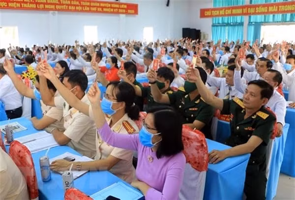 Các đại biểu biểu quyết thông qua Nghị quyết Đại hội Đảng bộ huyện Vũng Liêm, Vĩnh Long. Ảnh: TTXVN