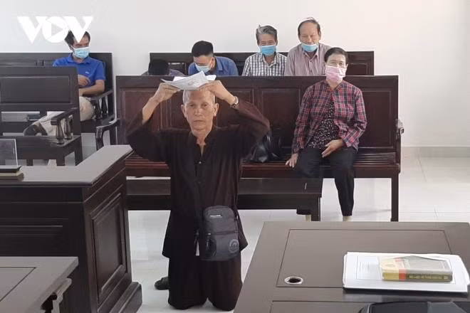 Cụ ông gần 80 tuổi Trần Hữu Sỹ quỳ gối, đội đơn xin tòa xét xử. Ảnh: vov.