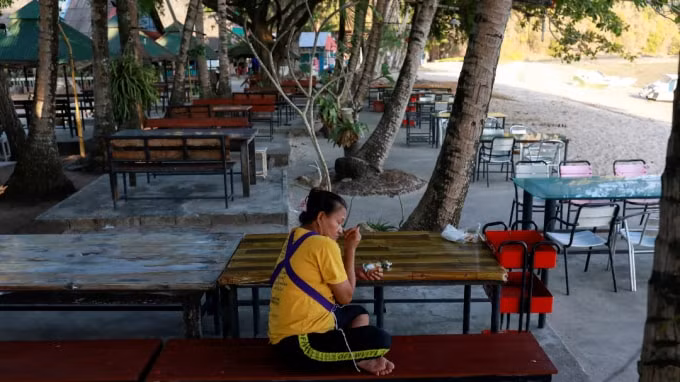 Một người phụ nữ ngồi gần bãi biển thường chật kín khách du lịch ở Phuket vào ngày 10 tháng 3. Bị ảnh hưởng nặng nề nhất là những người lao động phi chính thức với 81% những người làm du lịch bị mất việc làm. Ảnh: Reuters