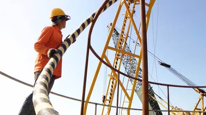 Thi công lắp đặt tuyến cáp ngầm xuyên biển 22kV đưa điện lưới quốc gia ra đảo Trần. Ảnh Đỗ Phương.