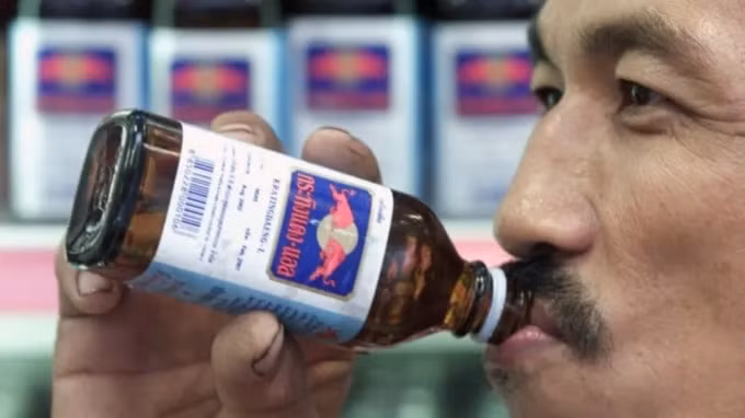 Một người đàn ông uống chai Krating Daeng, phiên bản chính gốc của thức uống nổi tiếng Red Bull của Thái Lan, trong một cửa hàng ở Bangkok. Ảnh: Reuters