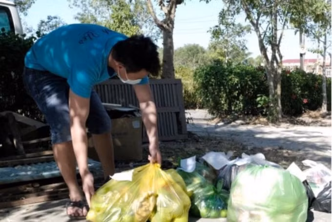 Sau khi đi mua từ nhiều chợ, một cán bộ y tế đang soạn lại các túi đồ người dân nhờ mua hộ để giao vào trong.