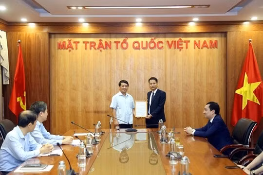Đồng chí Hầu A Lềnh trao quyết định tiếp nhận và bổ nhiệm cho tân Phó Tổng Biên tập Trương Thành Trung. Ảnh: PV