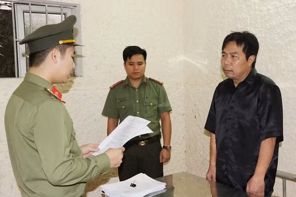 Tống đạt quyết định khởi tố bị can đối với Nguyễn Minh Cầm. Ảnh CAHT