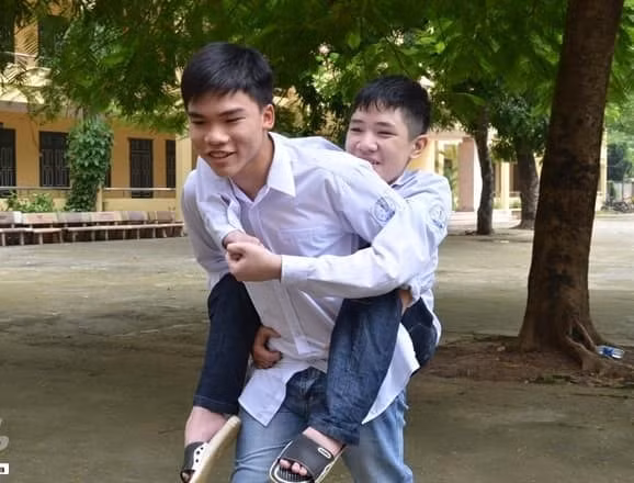 Suốt 4 năm qua, bất kể dù trời nắng hay mưa Phạm Anh Tú tình nguyện cõng bạn đến lớp. Ảnh Thanh Xuân.