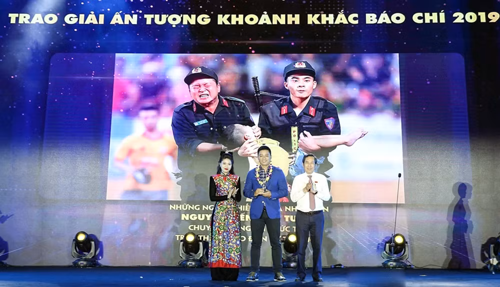 Ông Thuận Hữu, Ủy viên Trung ương Đảng, Tổng Biên tập báo Nhân dân, Phó Trưởng ban Tuyên giáo Trung ương, Chủ tịch Hội Nhà báo Việt Nam và MC, BTV Ngọc Trinh trao giải tác phẩm ảnh báo chí đạt Giải ấn tượng. Ảnh Sơn Hải