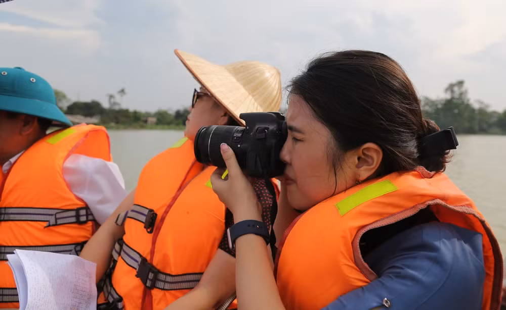 Phóng viên Hồ Thủy Tiên, báo Kinh Tế Đô Thị tác nghiệp trong đợt lũ rừng ngang năm 2018 tại huyện Chương Mỹ, Hà Nội. Ảnh Lê Anh