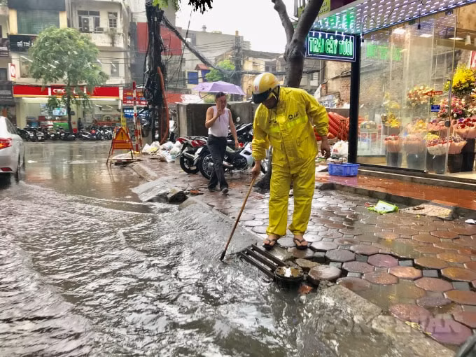 Công nhân khơi thông cống thoát nước để nước rút nhanh hơn