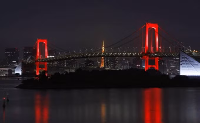 Thành phố Tokyo đã phải thắp sáng cây cầu Rainbow tuyệt đẹp ở vịnh Tokyo để cảnh báo cư dân cảnh giác virus ngày 2/6 vừa qua. Ảnh: KYODO