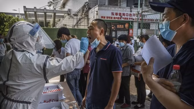 Người dân Bắc Kinh xếp hàng lấy mẫu xét nghiệm Covid-19. Ảnh: Reuters