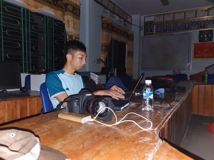 Dọc đường tác nghiệp, các phóng viên đối mặt khó khăn nhất là máy móc hết pin. Họ phải dùng sạc dự phòng cho điện thoại, máy tính để kịp chuyển tải thông tin, hình ảnh thiên tai về tòa soạn và bạn đọc một cách chính xác và nhanh nhất. Ảnh: T.P.