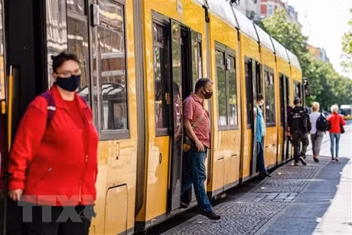 Hành khách đeo khẩu trang phòng lây nhiễm dịch COVID-19 khi lưu thông bằng xe điện ở Berlin, Đức ngày 27/4/2020. Ảnh: TTX.