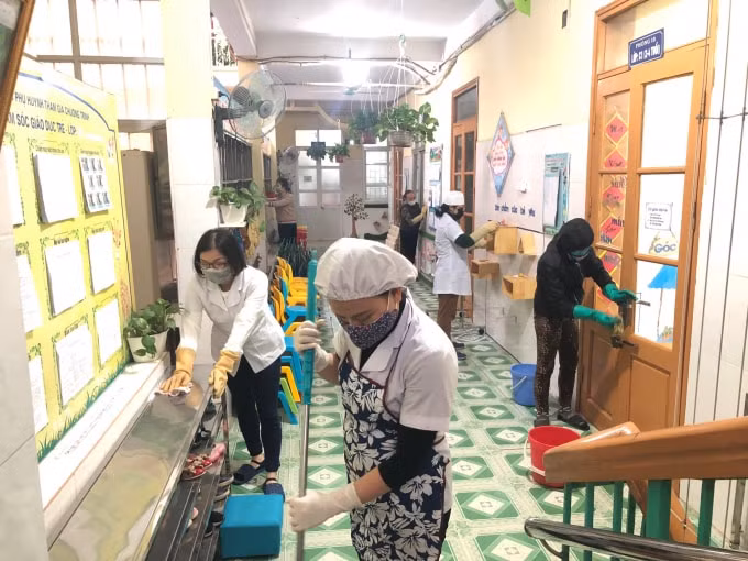 Các bậc phụ huynh cũng cùng nhà trường tham gia vệ sinh, phòng chống dịch. Ảnh: Hoàng Dương