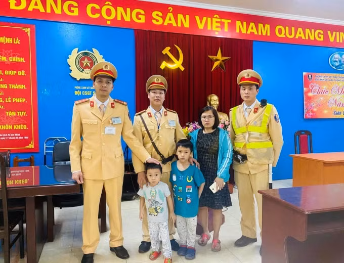 Cán bộ đội CSGT số 4 bàn giao hai bé về với gia đình. Ảnh: Nguyễn Hùng