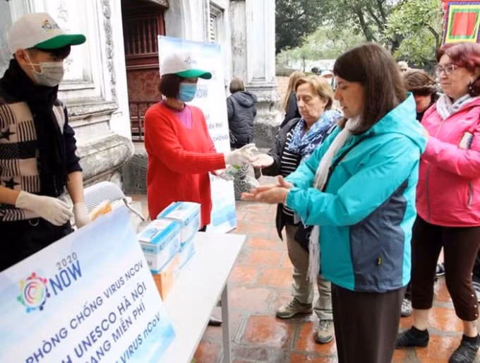 Khách du lịch được phát khẩu trang miễn phí và hướng dẫn rửa tay sát khuẩn tại nhiều điểm du lịch trên địa bàn Thủ đô. Ảnh: TL