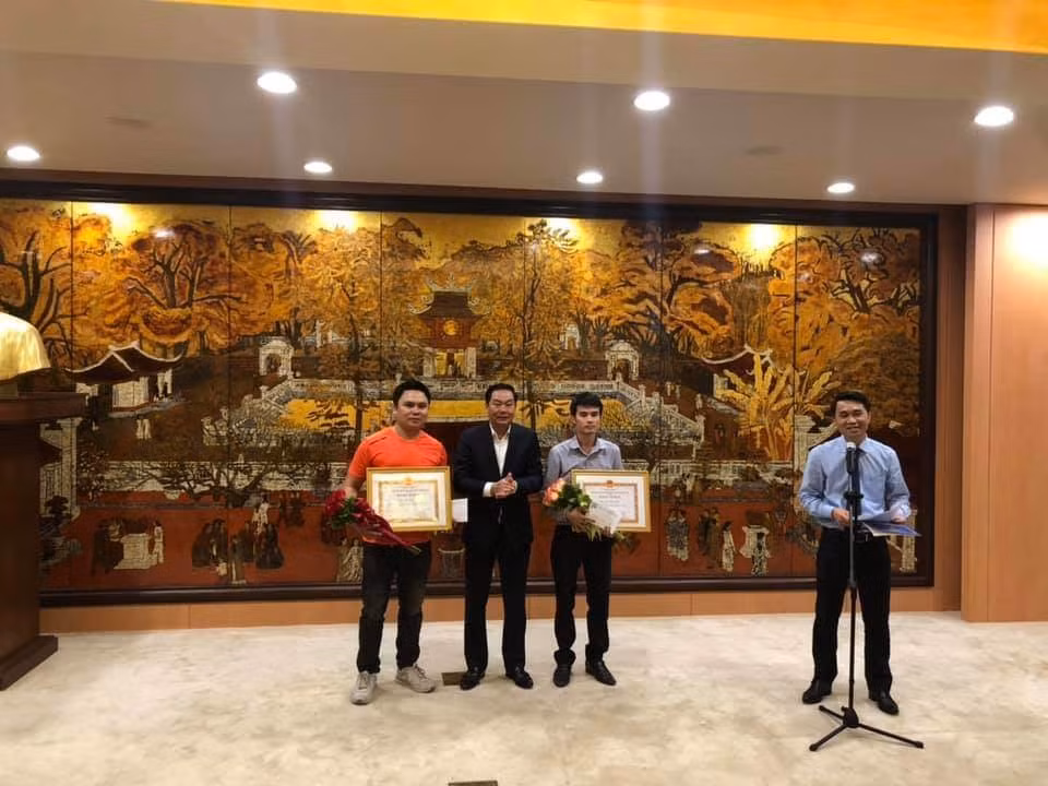 Lãnh đạo thành phố Hà Nội tặng bằng khen cho PV Chu Văn Lương (phải) và Đỗ Văn Trụ (trái)