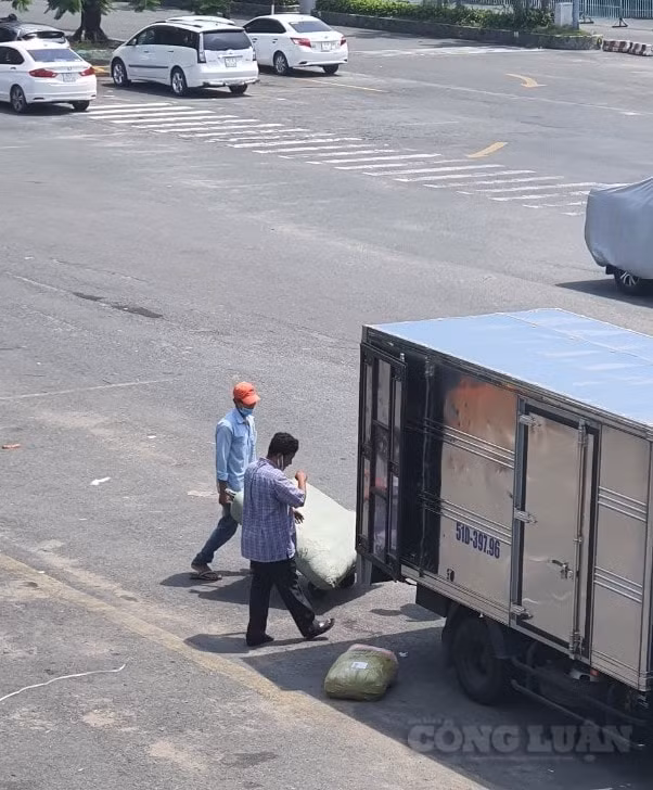 Ngoài sân, vài người bốc xếp hàng hoà đang làm việc.