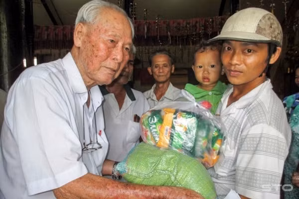 Cụ Trần Cang tặng quà cho người nghèo. Ảnh: TNO