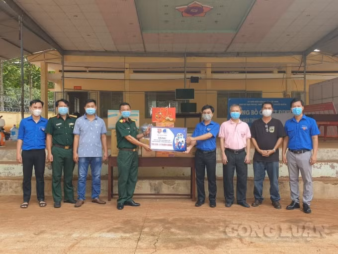 Ông Trần Quốc Duy (thứ 4 từ trái sang) trao bảng tượng trưng các nguồn lực hỗ trợ khu cách ly tập trung tại trường THPT Lộc Ninh (cũ)
