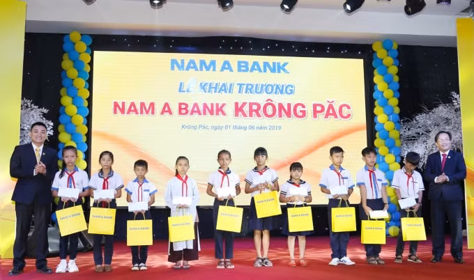 Ông Võ Anh Tú – Giám đốc Nam A Bank Đắk Lắk (bên phải) và Ông Vũ Xuân Phúc – Giám đốc Nam A Bank Krông Păc (bên trái) trao học bổng cho các em học sinh nghèo vượt khó.