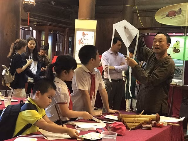 Các em thiếu nhi tham gia tương tác, làm diều cùng các nghệ nhân đến từ Thái Bình tại buổi lễ khai mạc chiều 1/6. Ảnh: Bao toquoc