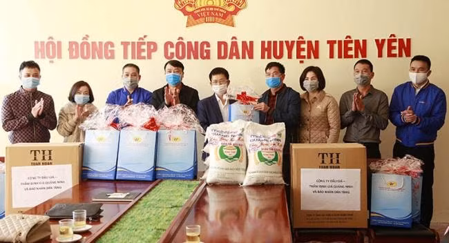 Ông Đỗ Ngọc Hà, Phó Chủ tịch Hội Nhà báo tỉnh (người đứng giữa) và đại diện các đơn vị tài trợ, trao tặng quà Tết và khẩu trang y tế cho đại diện chính quyền huyện Tiên Yên. Ảnh: Trần Hoàn.