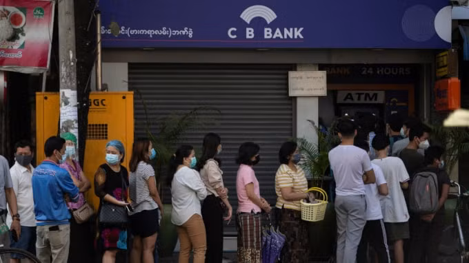 Đám đông người dân xếp hàng bên ngoài một cây ATM để rút tiền. Ảnh: Reuters