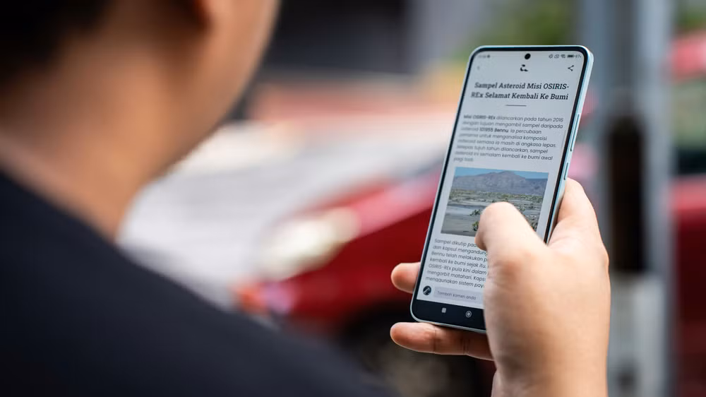 a person holding a cell phone in their hand