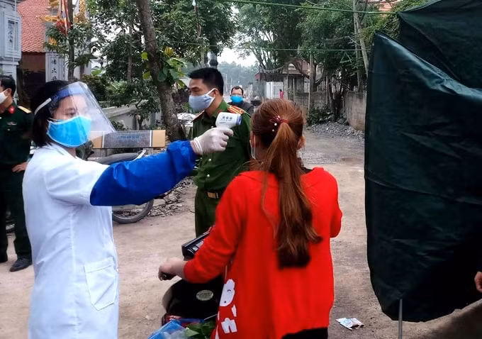 Lực lượng chức năng phong tỏa, kiểm tra y tế tại xã Bình Nghĩa, huyện Bình Lục (Hà Nam) sau khi ghi nhận ca mắc Covid-19. Ảnh TL.