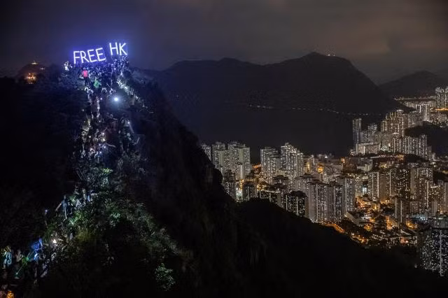 Hàng trăm người leo lên đỉnh núi Lion Rock cùng với dòng chữ 