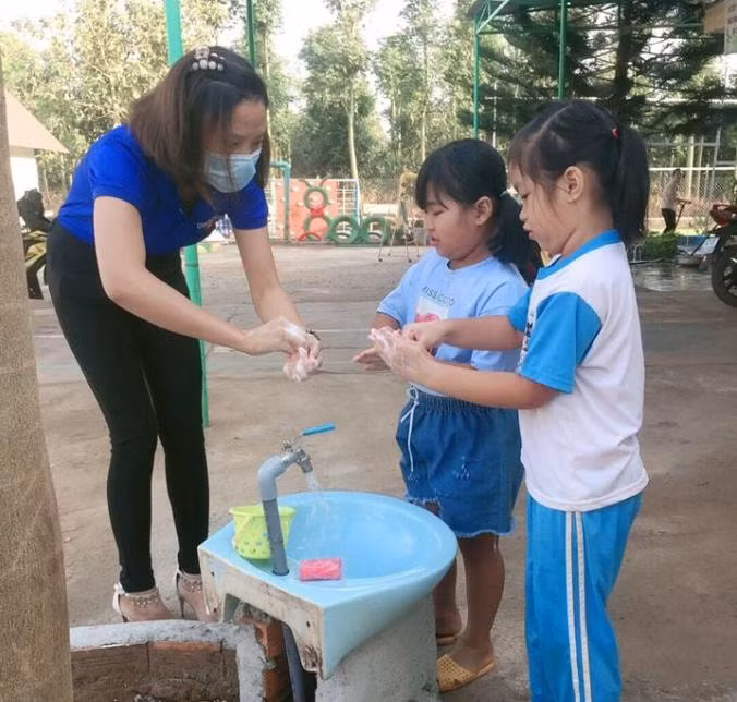 Các em học sinh được các bạn đoàn viên cơ sở hướng dẫn rửa tay sát khuẩn