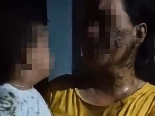 Người mẹ và cháu bé 2 tuổi bị đổ chất xú uế. Ảnh cắt từ clip