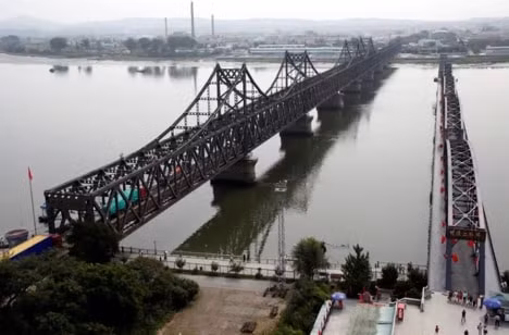Xe tải qua Cầu Hữu nghị từ Đan Đông, tỉnh Liêu Ninh của Trung Quốc đến Sinuiju, Triều Tiên (Nguồn : Finance Yahoo Photo).