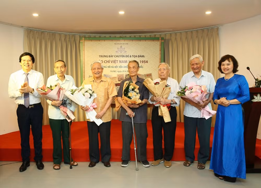 Phó Chủ tịch Thường trực Hội Nhà báo Việt Nam Hồ Quang Lợi và giám đốc Bảo tàng báo chí Việt Nam Trần Kim Hoa tặng hoa những nhà báo lão thành tham dự tọa đàm. Ảnh: Sơn Hải