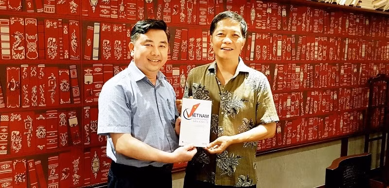 Tổng Biên tập báo Kinh tế&Đô thị tặng sách ''Việt Nam, một lối rẽ kinh tế'' cho Ủy viên Bộ Chính trị, Trưởng ban Kinh tế Trung ương Trần Tuấn Anh. Ảnh: Quang Tấn