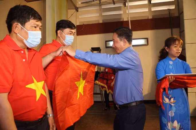 Ông Bùi Thanh Liêm, Phó Tổng Biên tập Báo Người Lao Động, trao cờ Tổ quốc cho đại diện các nghiệp đoàn khai thác hải sản. Ảnh: Quang Liêm
